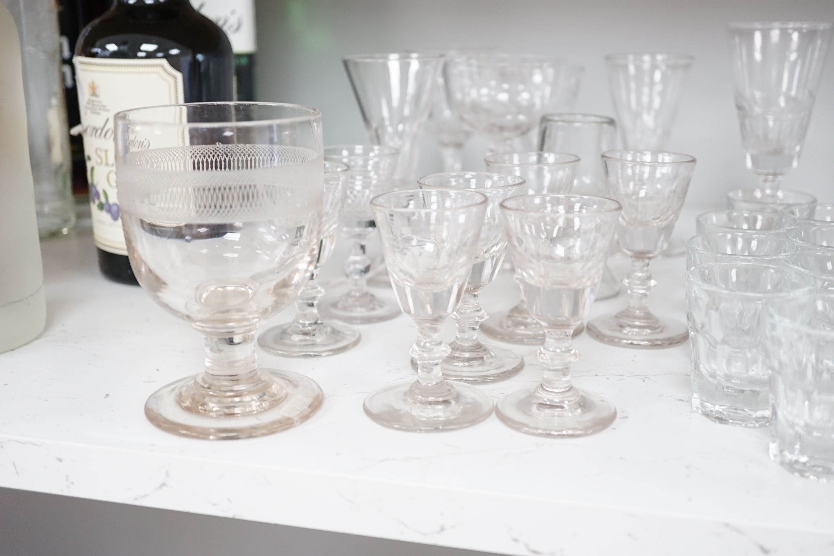 A collection of early 19th to early 20th century drinking glasses, including a set of twelve shot glasses, a set of six liqueur glasses, plus nine other wine, gin and sherry glasses of various sizes, tallest 14.5cm (27)